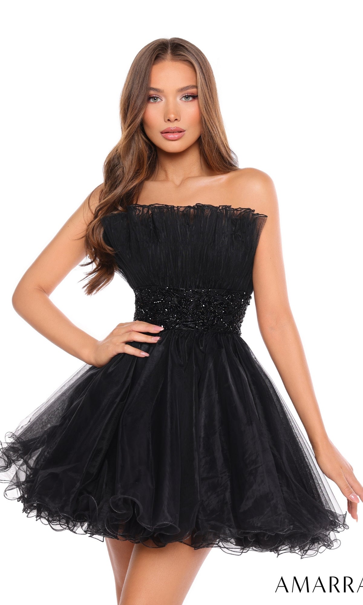 A woman wears the Short Homecoming Dress 88038 by Amarra—a strapless, knee-length black tulle dress with a fitted beaded waist and ruffled skirt.